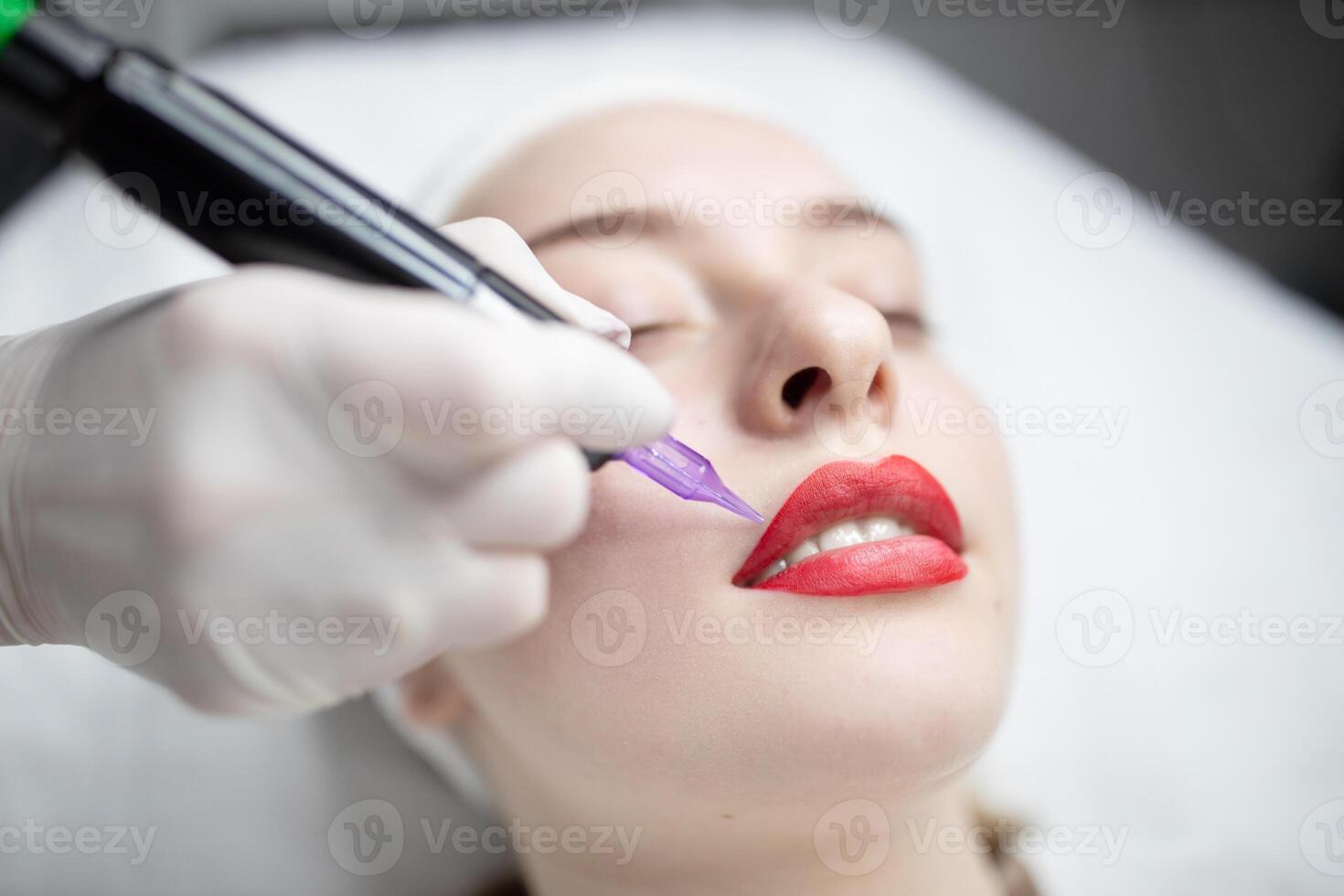 A skilled technician applies long-lasting lip color during a pampering session at a beauty salon. The client relaxes with closed eyes, enjoying the transformative treatment. photo