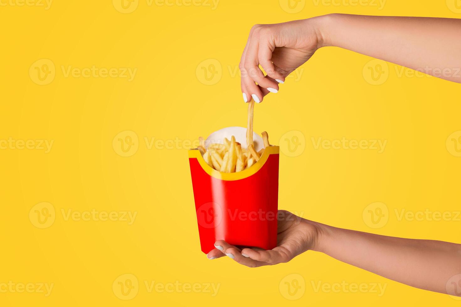 KHARKIV, UKRAINE - APRIL 4, 2020. Young girl holding pack of french fries from McDonald's on pink background, copy space photo