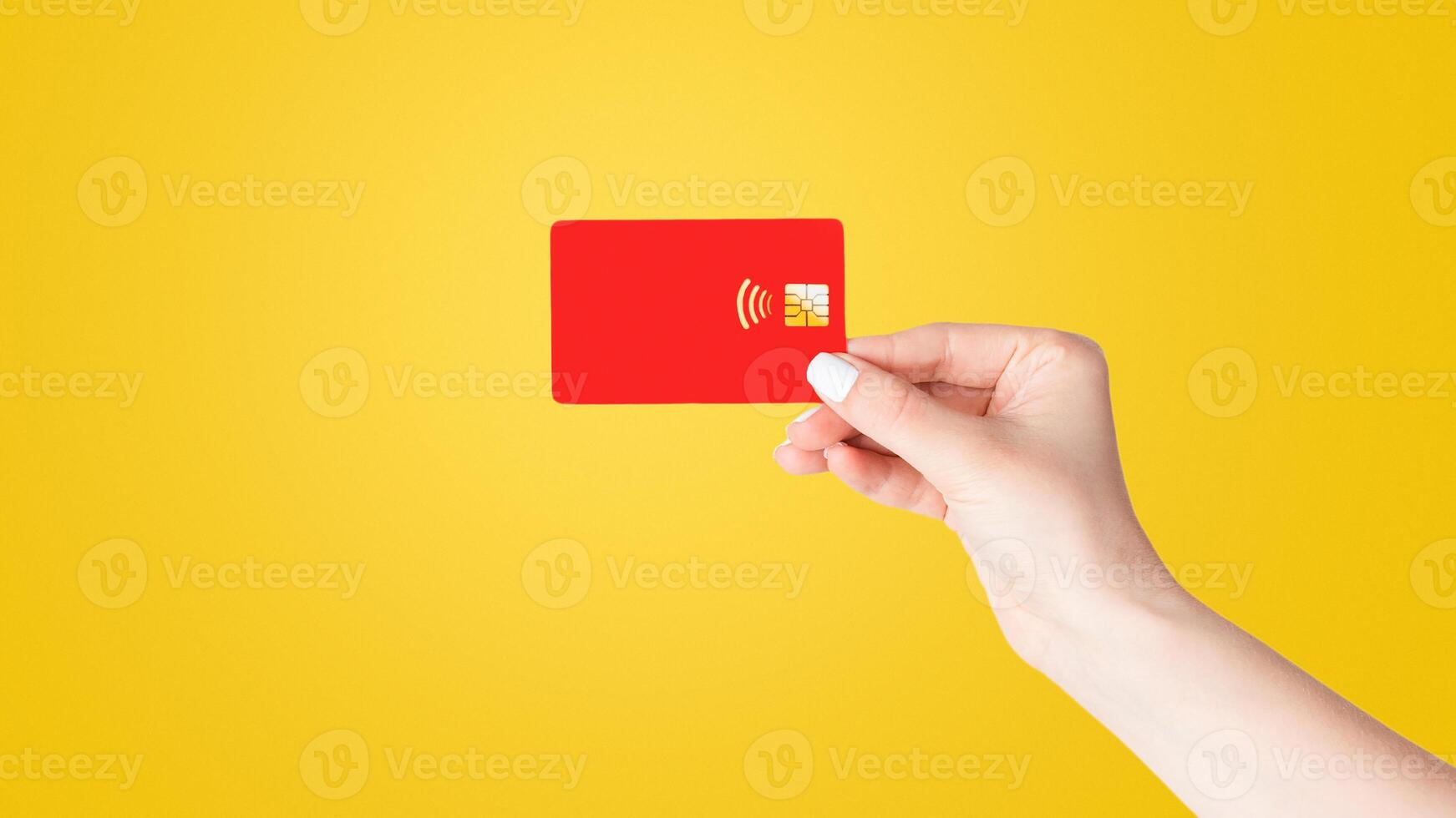 Close up of young female holding credit card for contactless payment on white background, isolated photo