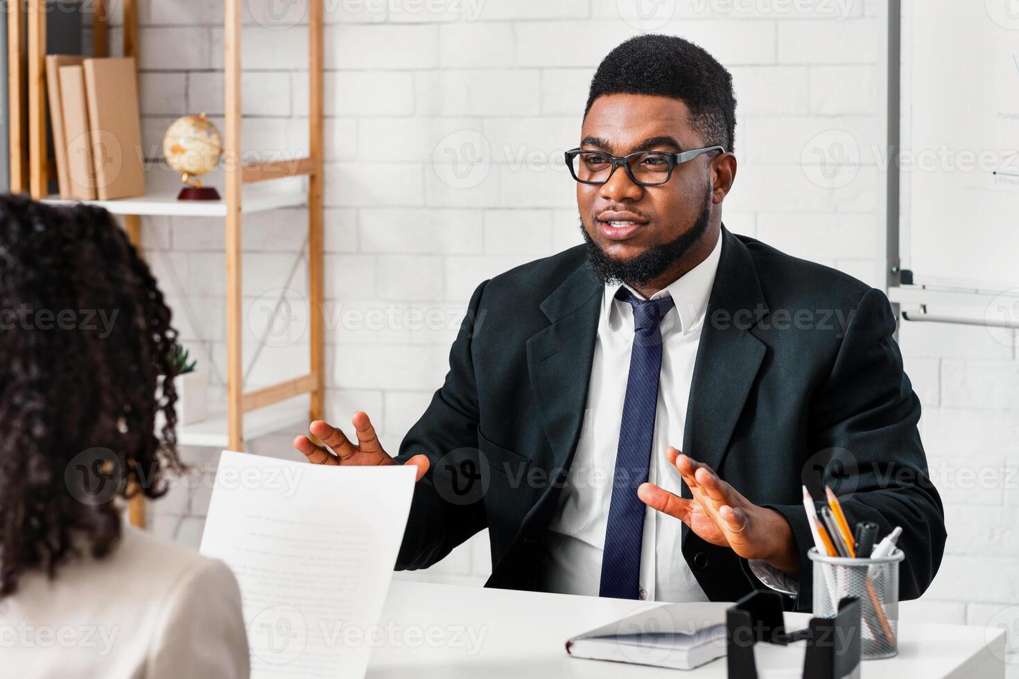 Young applicant answering HR manager's questions during job interview at office photo