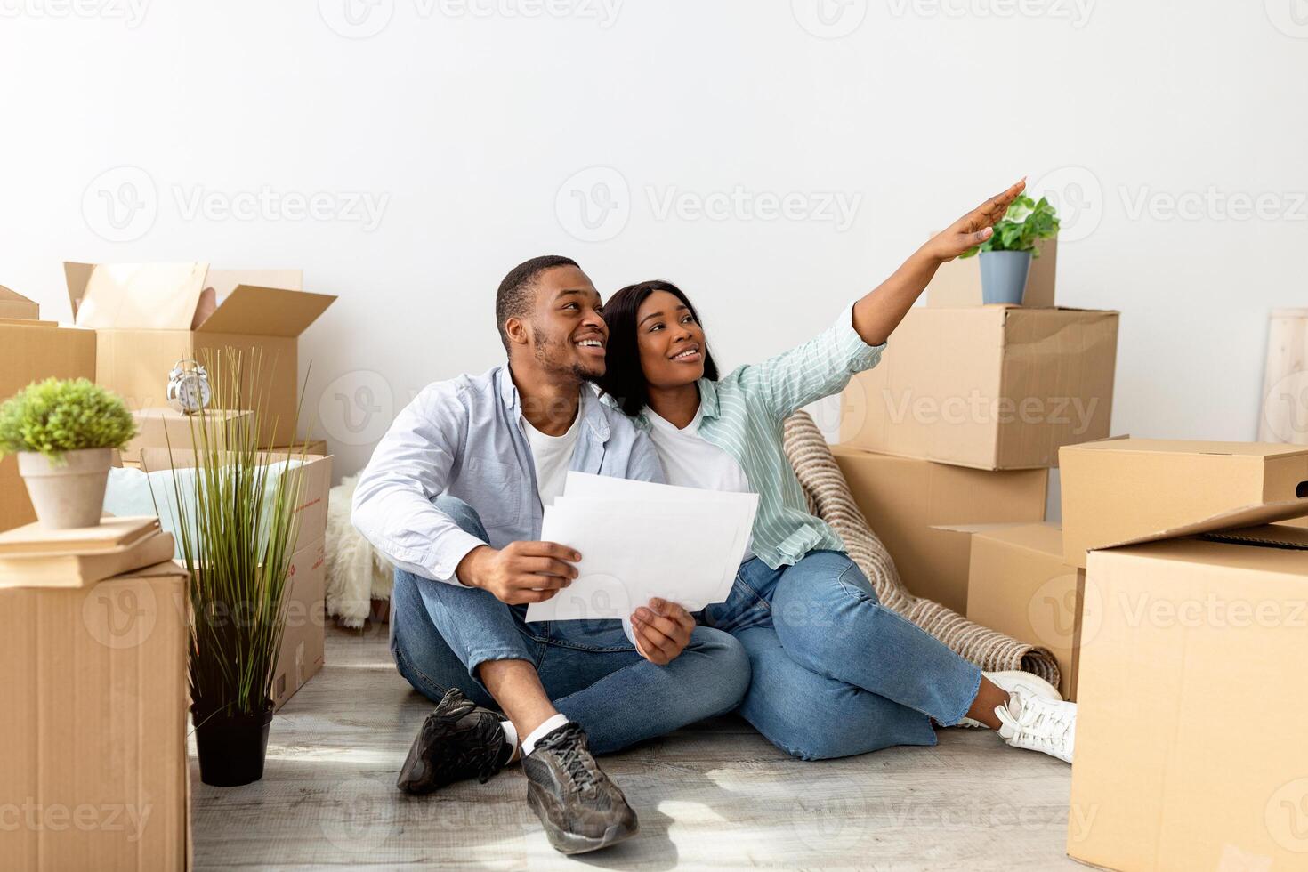 Excited black spouses sitting with laptop and imagining design in their new flat, discussing future home interior together after moving to own house, copy space photo