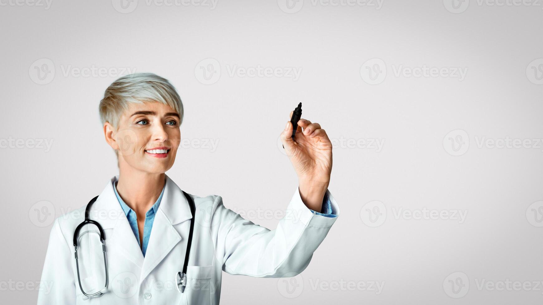 Diagnostics concept. Woman doctor write with marker on virtual board, isolated on light background, studio shot photo
