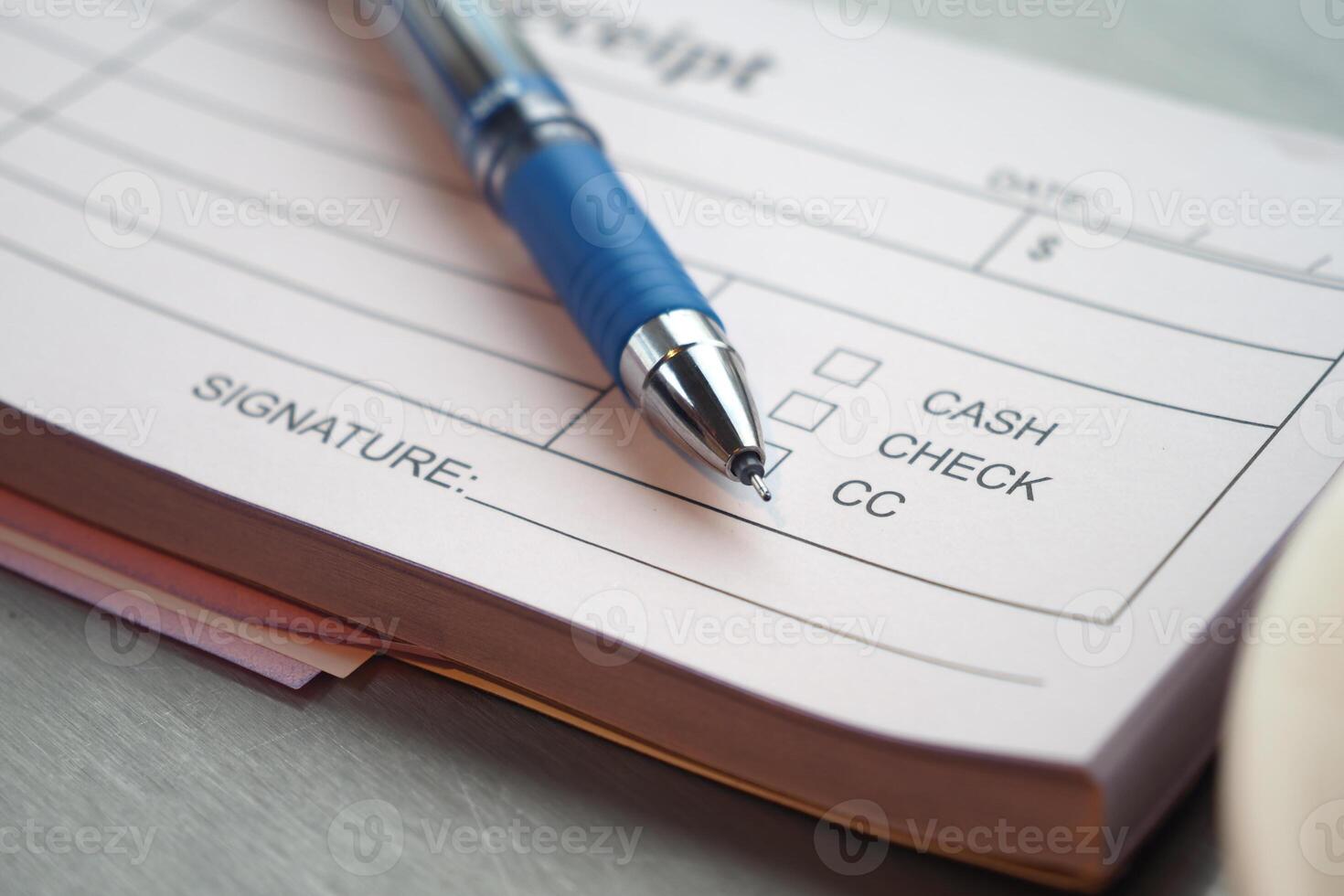 A Detailed Receipt Placed on the Table Surface with a Pen Nearby photo