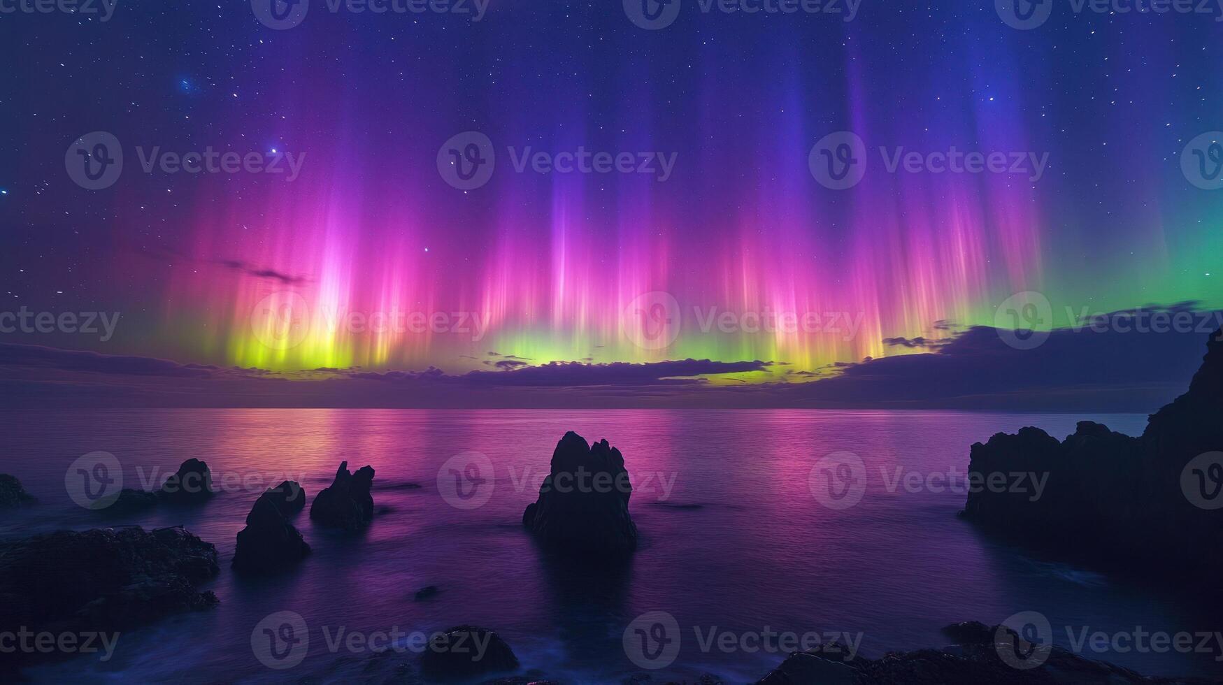 Colorful aurora borealis lights up the sky above the calm ocean and rugged rocks at twilight photo