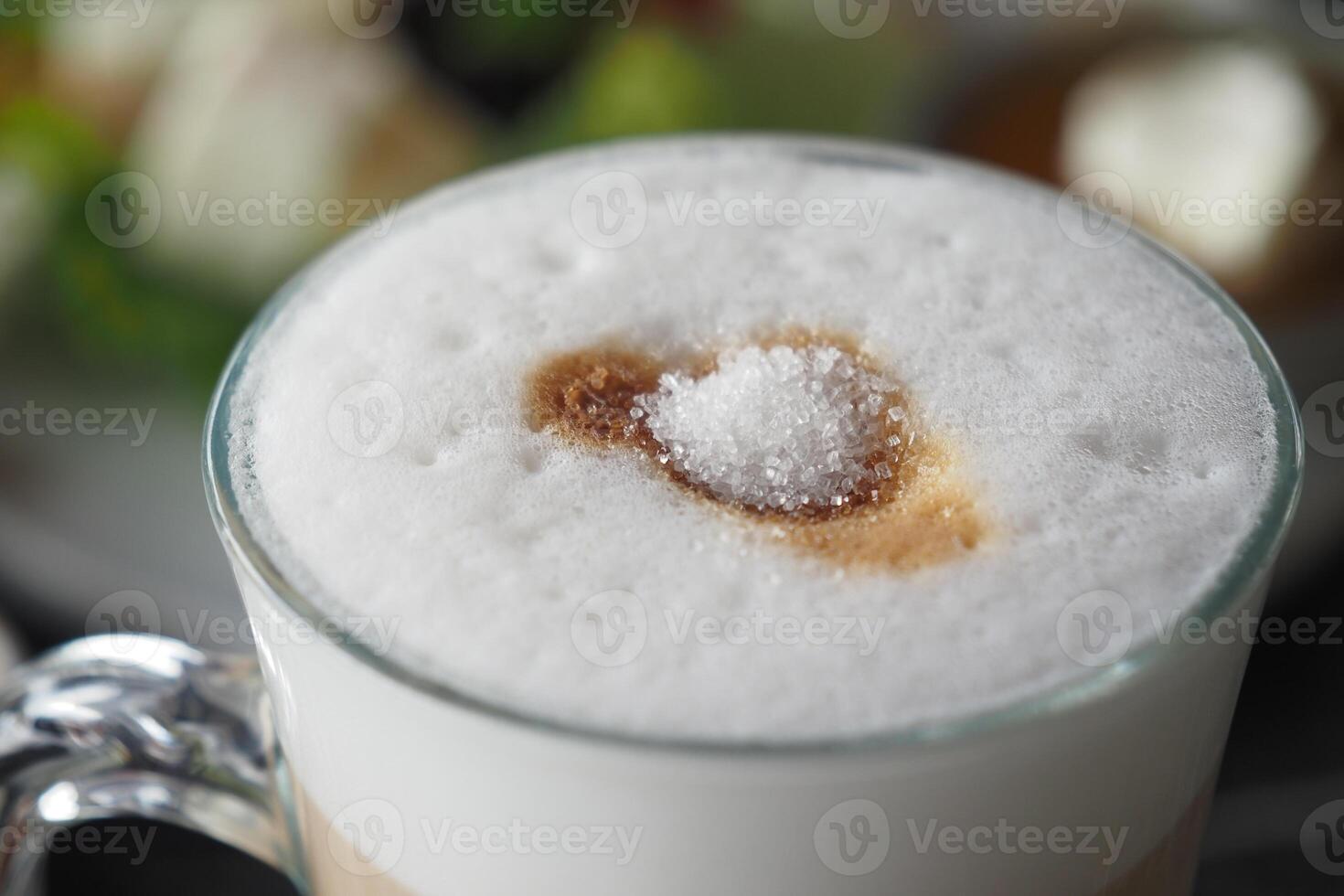 white sugar pouring from a in a paper packet on a coffee cup photo