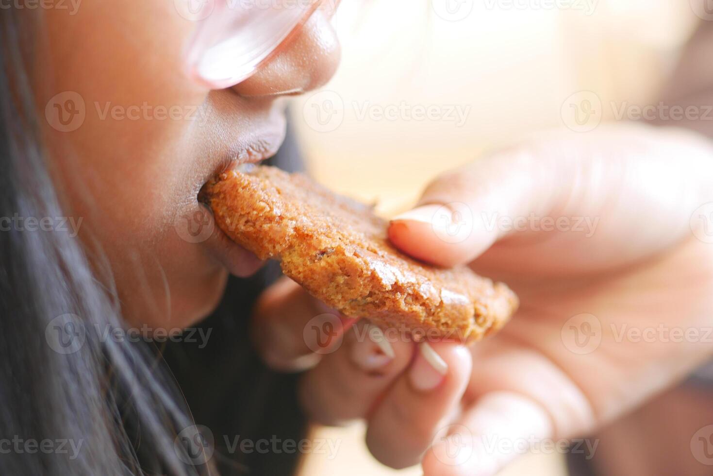 A Child Joyfully Enjoying a Delicious Cookie Given to Them by an Adult photo