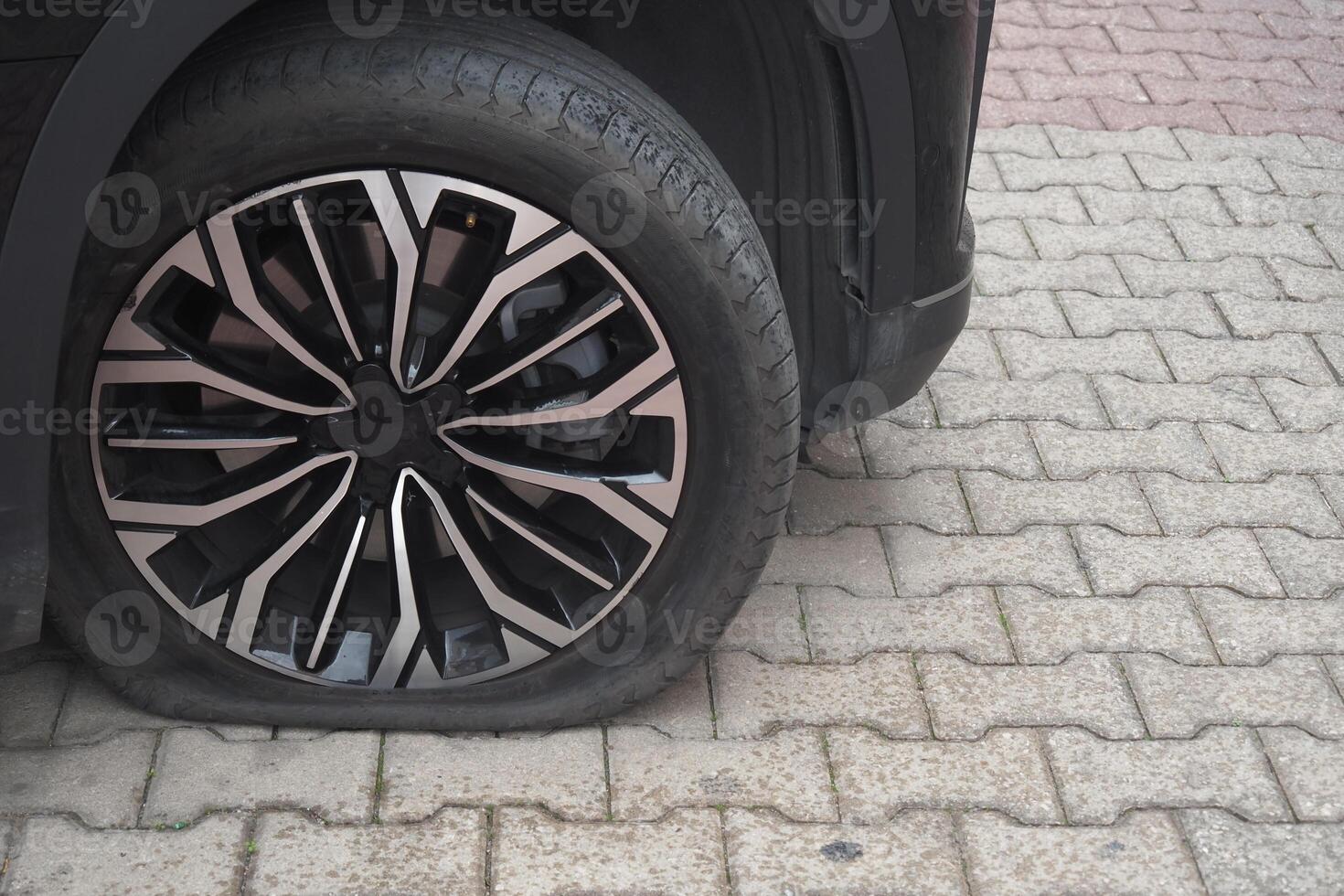 Flat Tire Close-Up on Paved Ground Depicting Auto Repairs Situation photo
