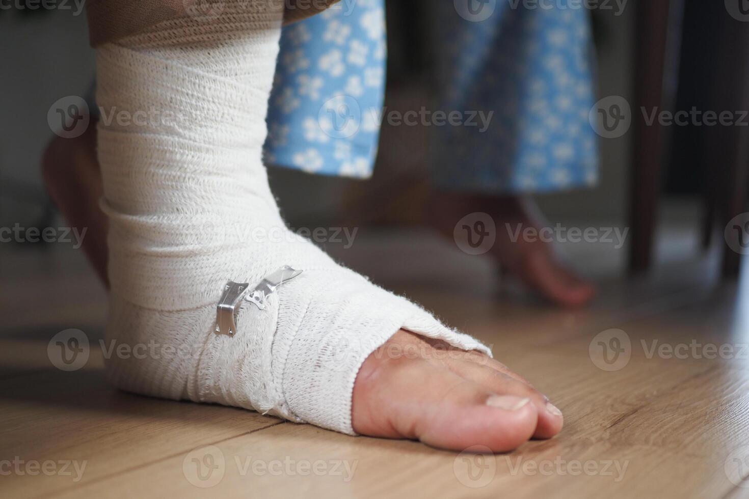 An injured foot wrapped in a bandage is gently resting on the floor, awaiting care and healing photo