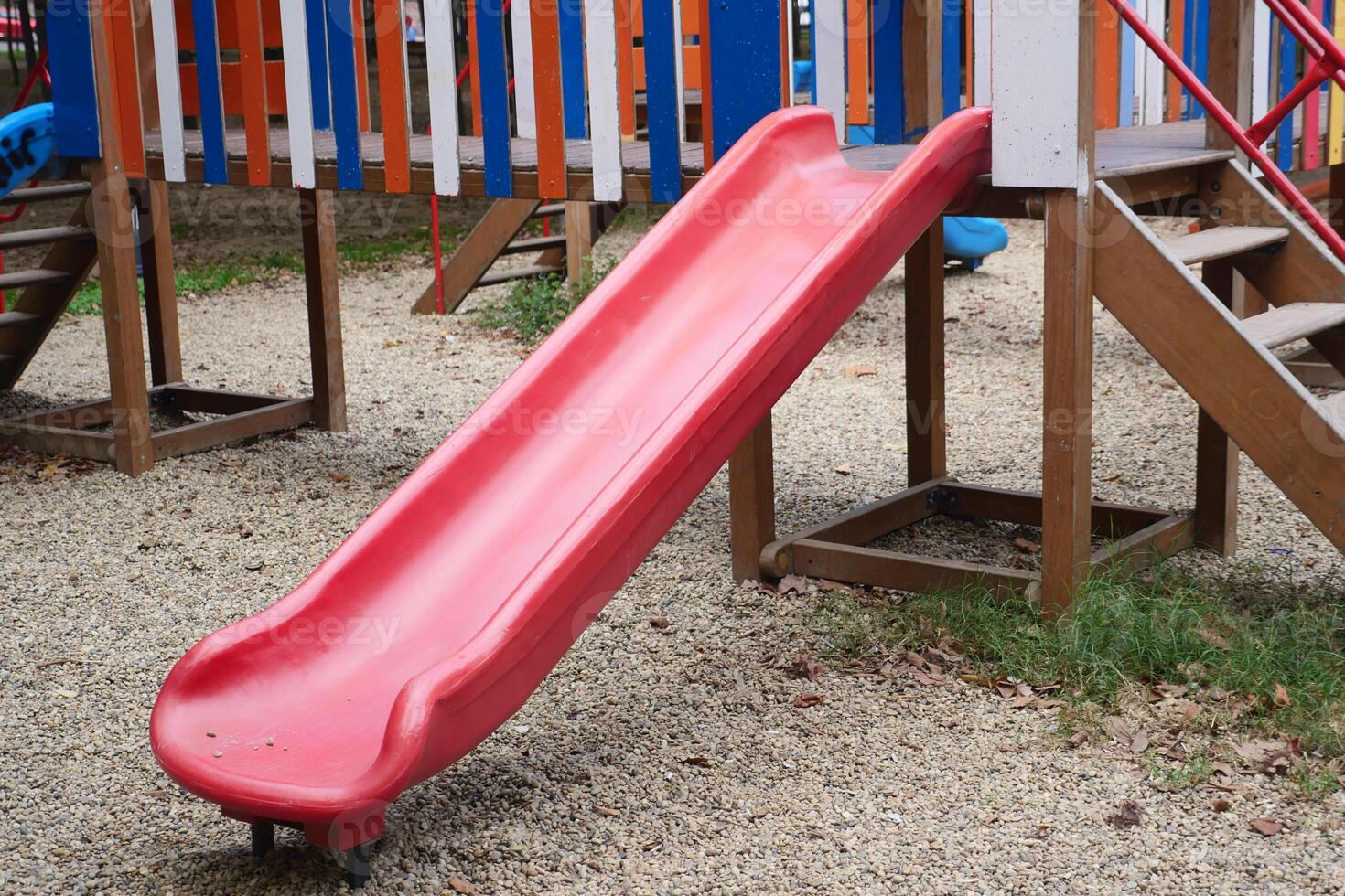 Bright Red Playground Slide Located in Outdoor Recreational Play Area photo