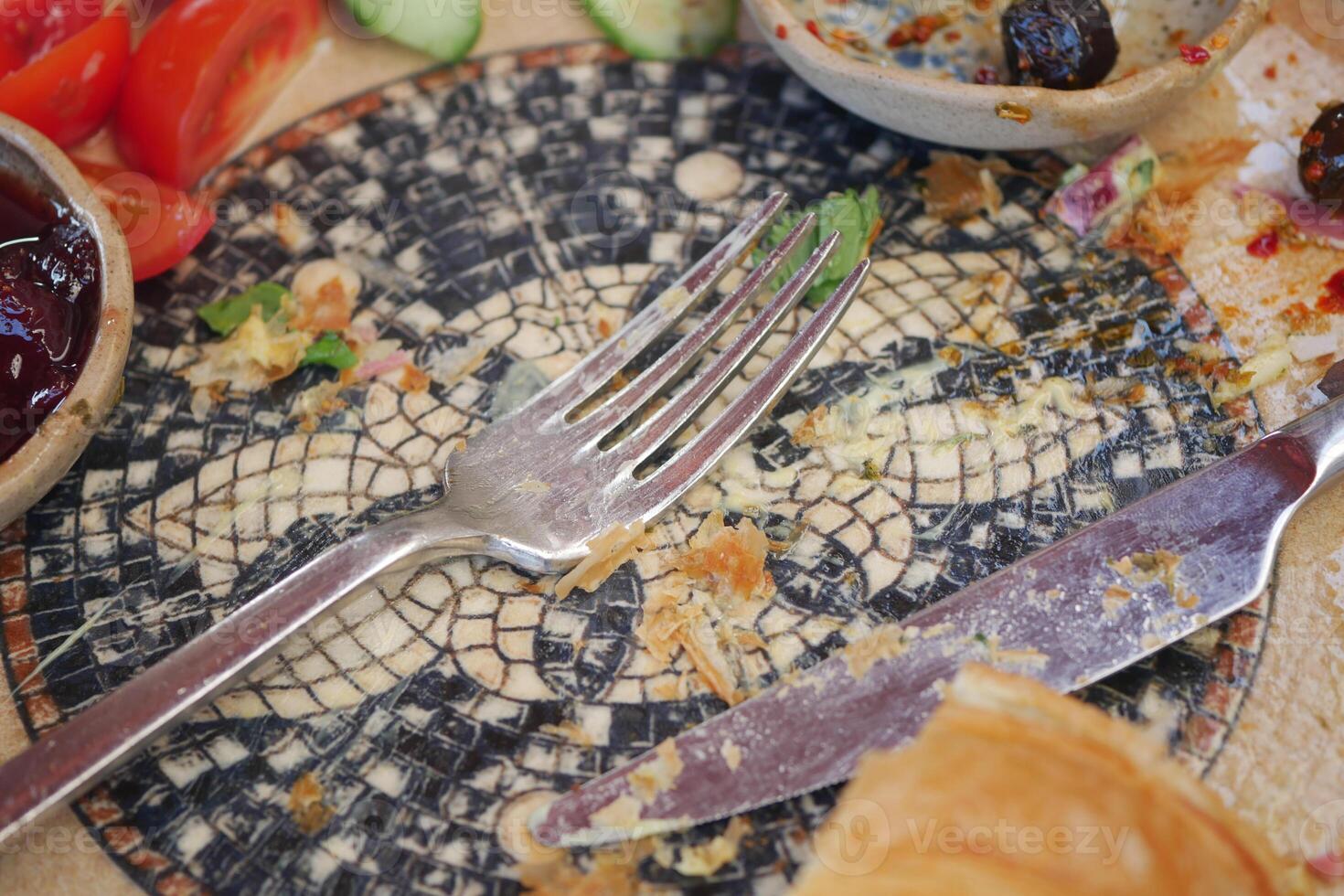 An empty dirty plate with a fork. photo