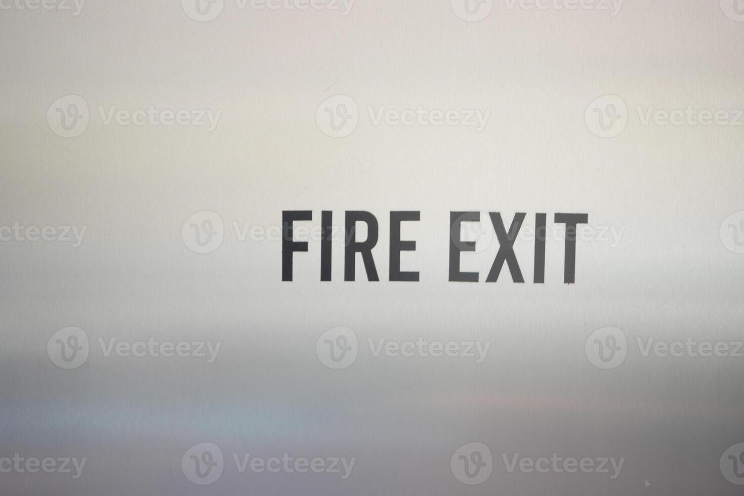 Fire Exit Signage prominently displayed in an Urban Environment alongside a Yellow Taxi cab photo