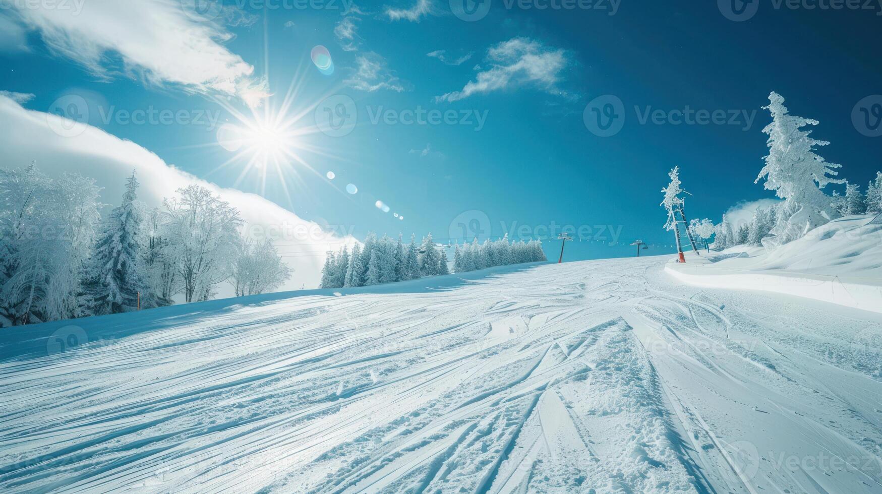Snow-covered ski slope with a bright blue sky and a shining sun photo
