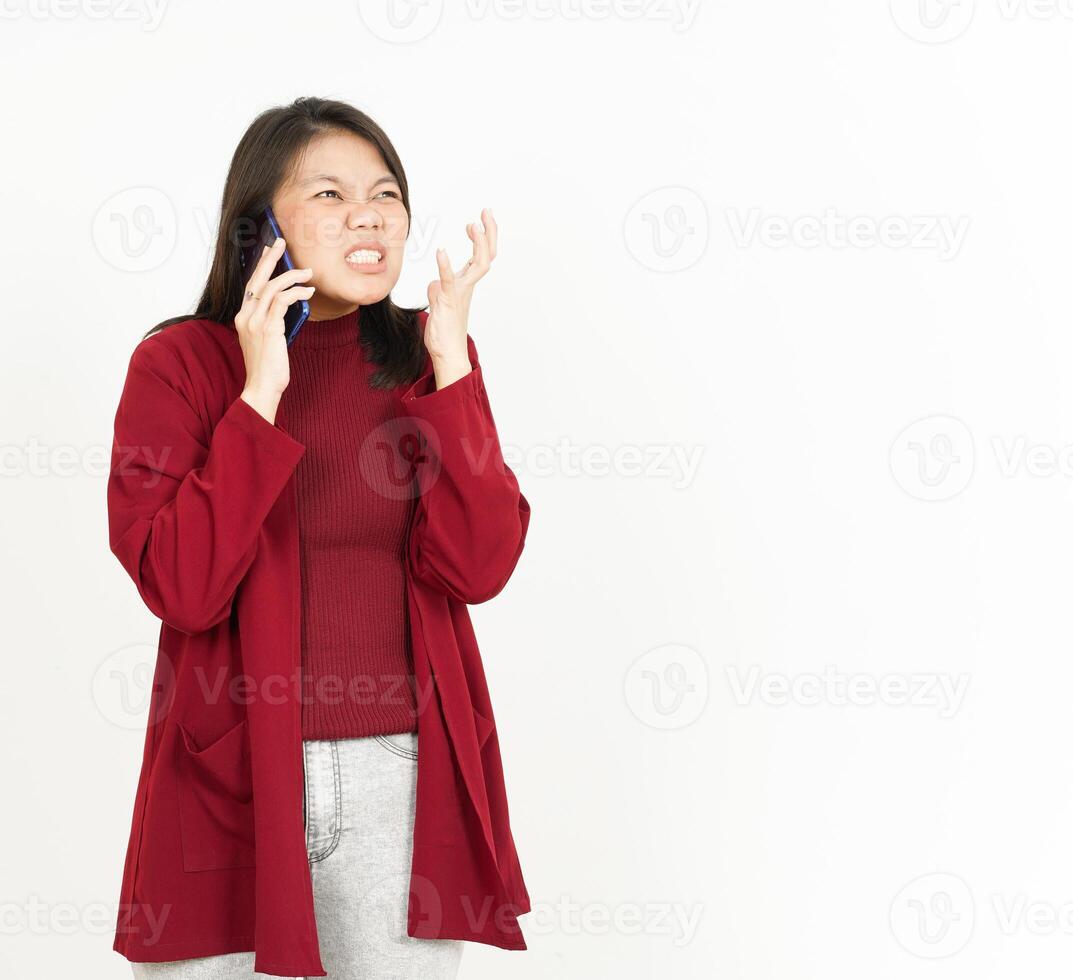 Talking on the Phone with Angry Face Of Beautiful Asian Woman Wearing Red Shirt Isolated On White photo