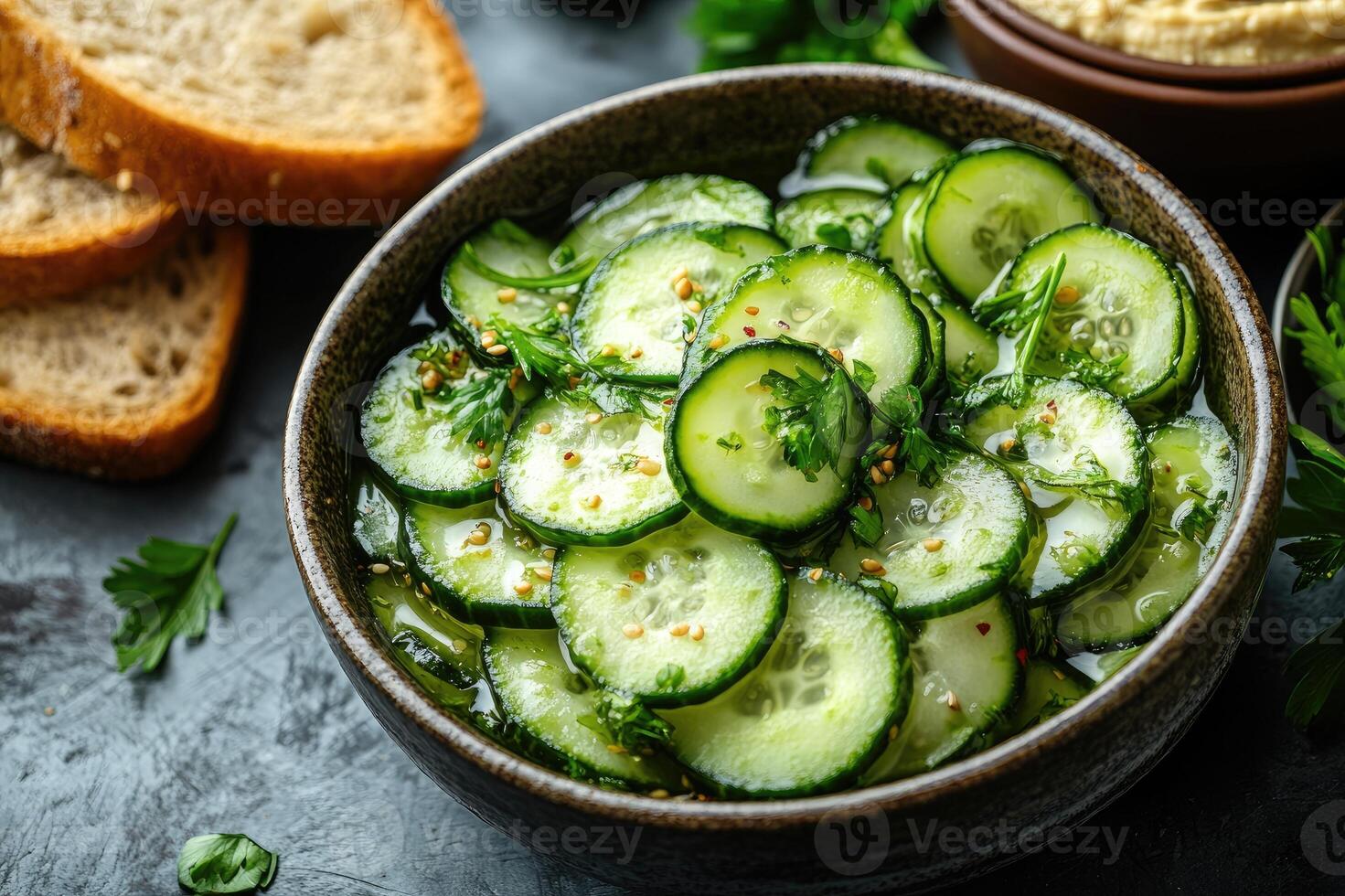 Sliced cucumber salad with parsley and black pepper seasoning in bowl photo