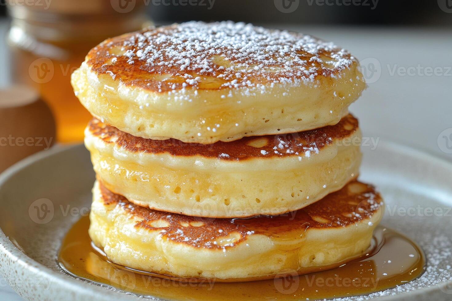 Fluffy pancakes stacked with syrup and powdered sugar photo
