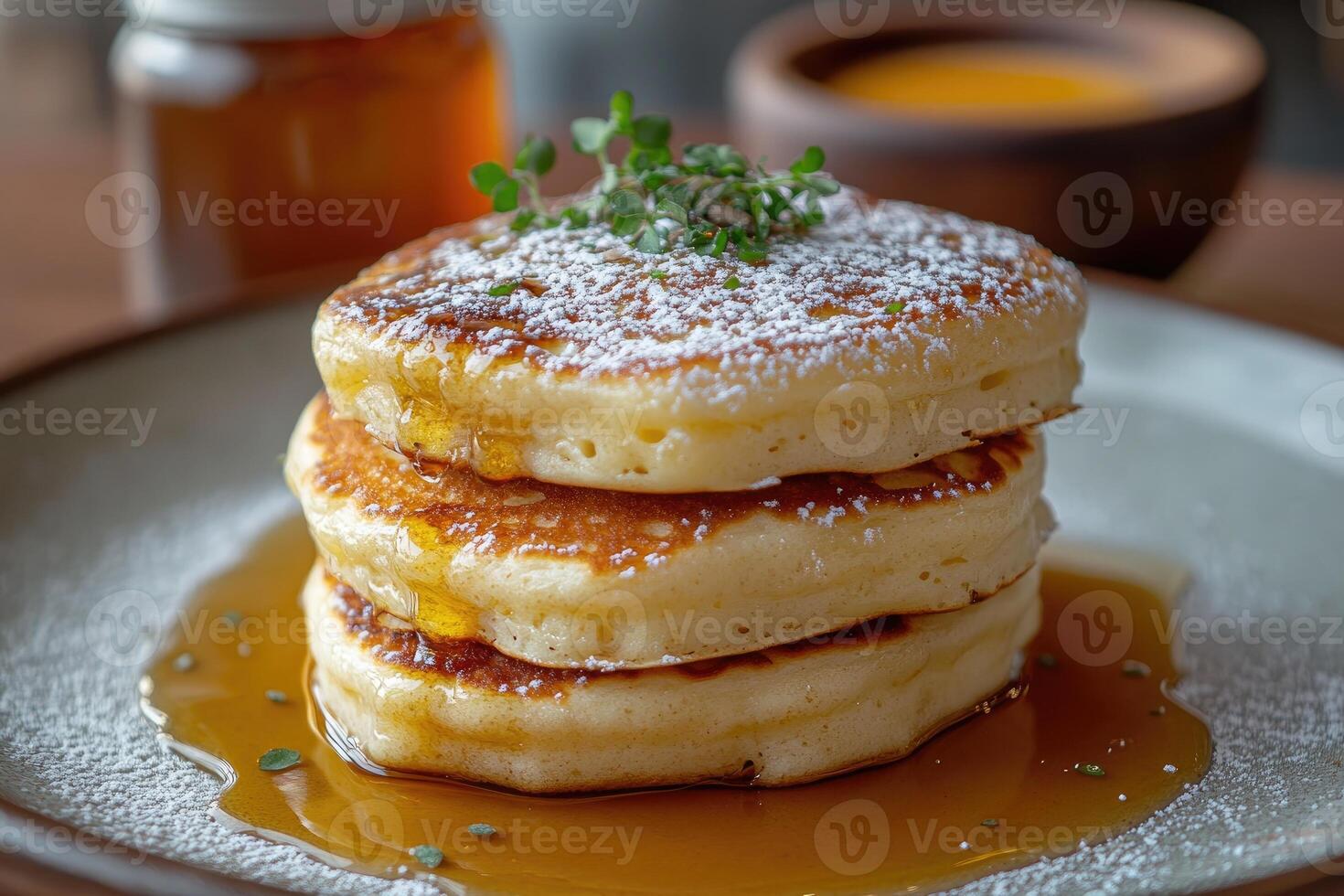 Stack of fluffy pancakes dripping with honey and icing sugar for a sweet breakfast photo