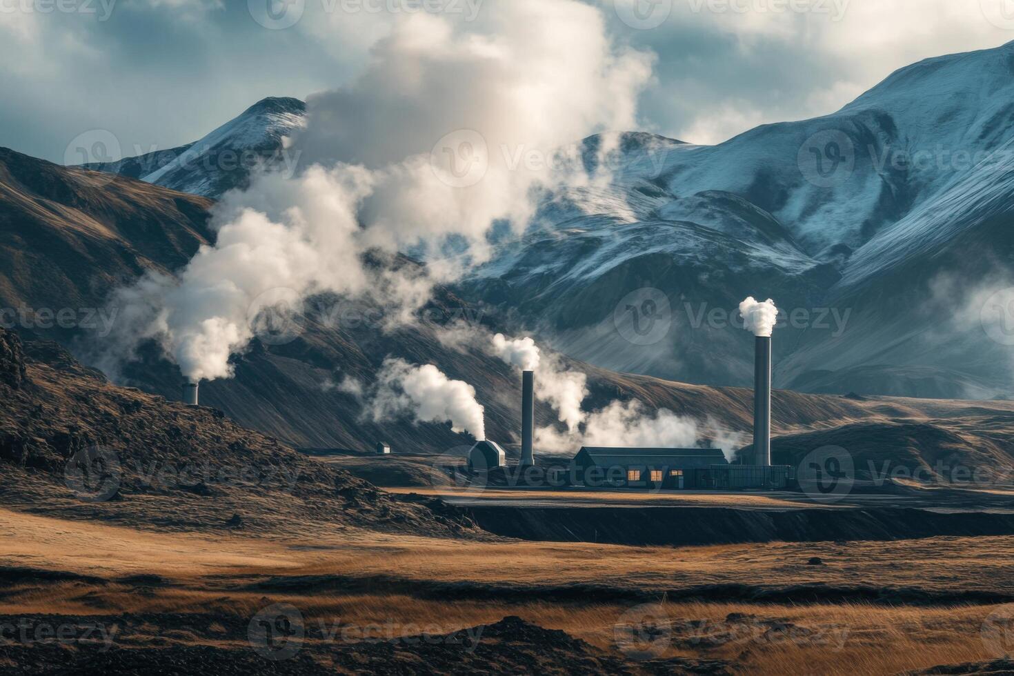 Steam rises from geothermal power plant located in Iceland's stunning mountainous landscape during late afternoon light photo