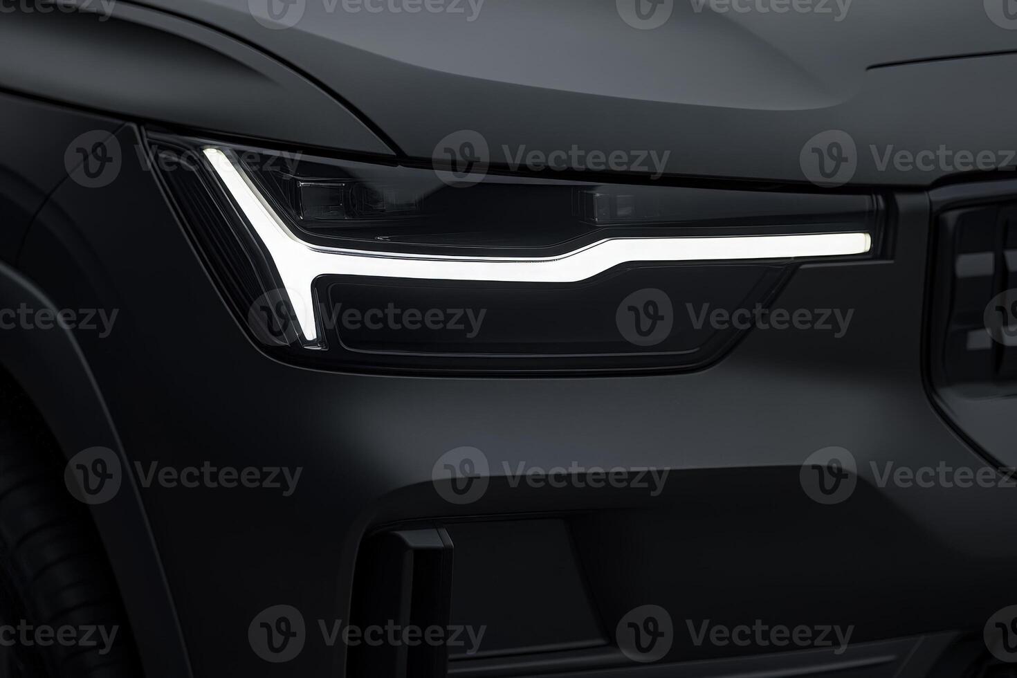 A close-up of a vehicles headlight highlights its sleek design and striking light graphic in low light, showcasing innovation in automotive engineering. photo