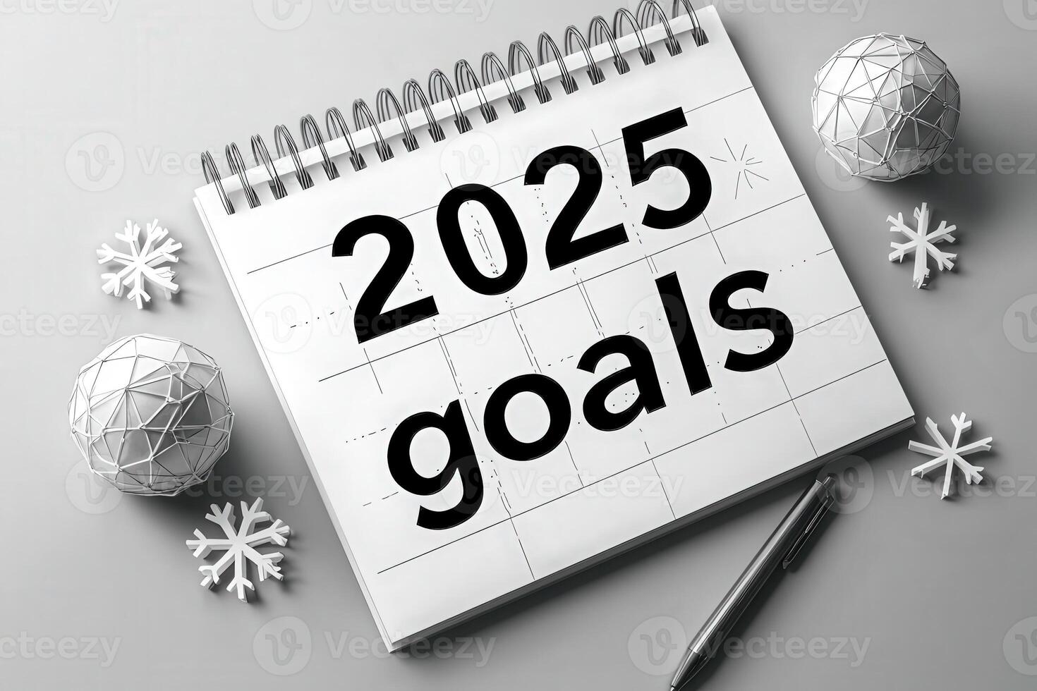 A planner page displays the bold text 2025 goals, surrounded by decorative snowflakes and a pen, emphasizing the importance of planning and focus for the upcoming year. photo