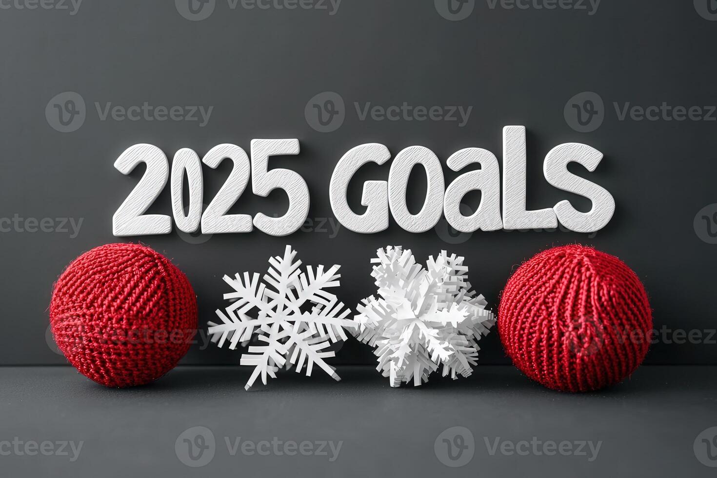 Decorative text features 2025 goals prominently displayed with red yarn balls and white snowflakes, set against a dark background, perfect for inspiring annual planning and motivation. photo