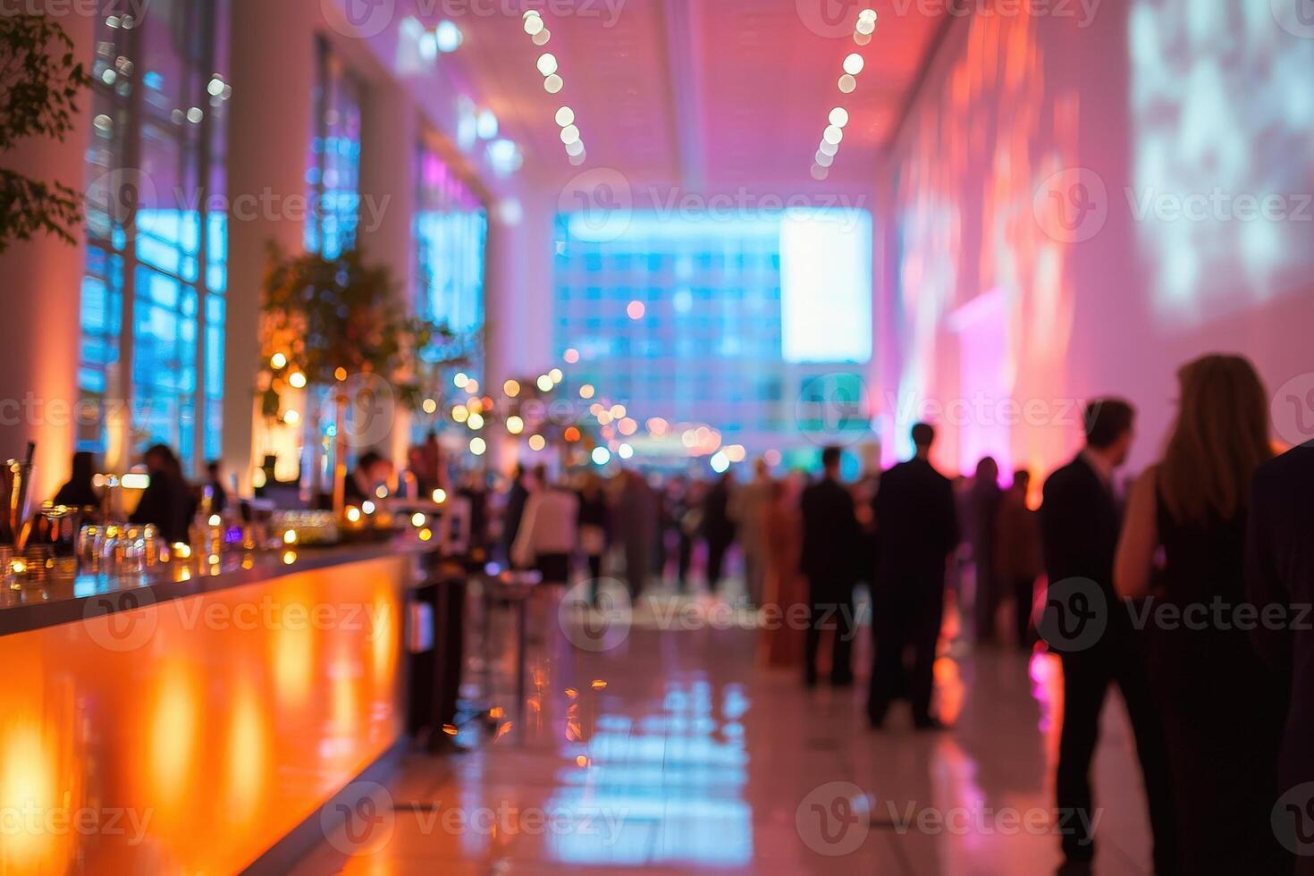 A sophisticated gathering unfolds in a spacious contemporary venue. Guests enjoy the stylish decor, vibrant lighting, and lively ambiance, creating a memorable evening experience. photo
