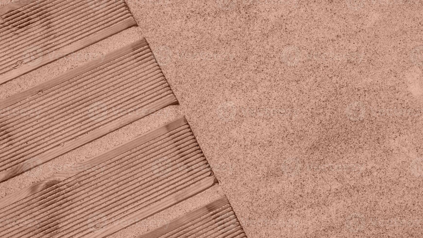 Top view of a wooden pier on the coast with sand. Abstract background from summer travel with copy space. Mocha Mousse, Color of the Year 2025. photo