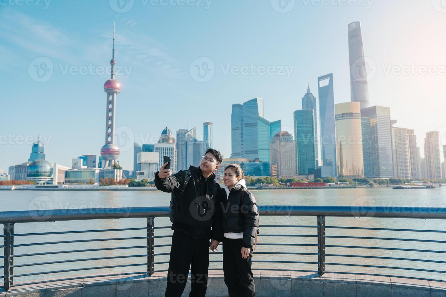 Couple traveler visiting in Shanghai, China. Tourists sightseeing Shanghai view of Lujiazui on The Bund of Shanghai. landmark and popular for tourism attractions. Vacation concept photo