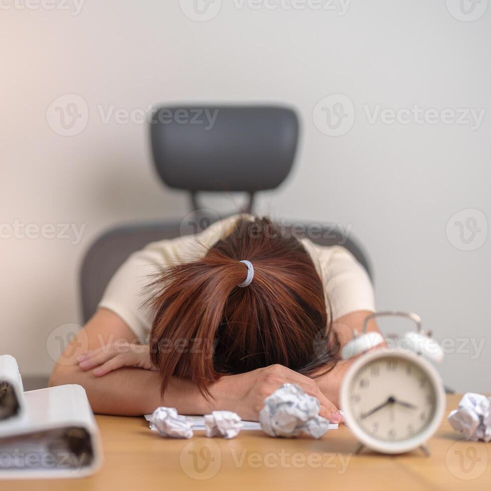 Stressed woman having Tired and Sleepy while working, female businesswoman having headache at office, Exhausted woman with documents folder stack and clock at home late night. Overworked and Overtime photo