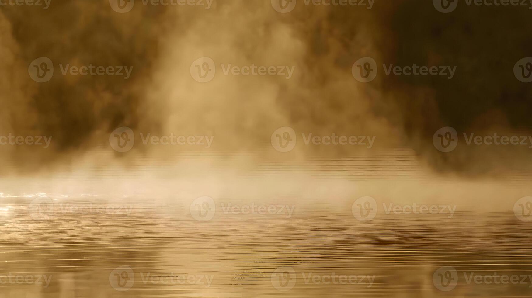 Golden steam rising from calm water at dawn. photo