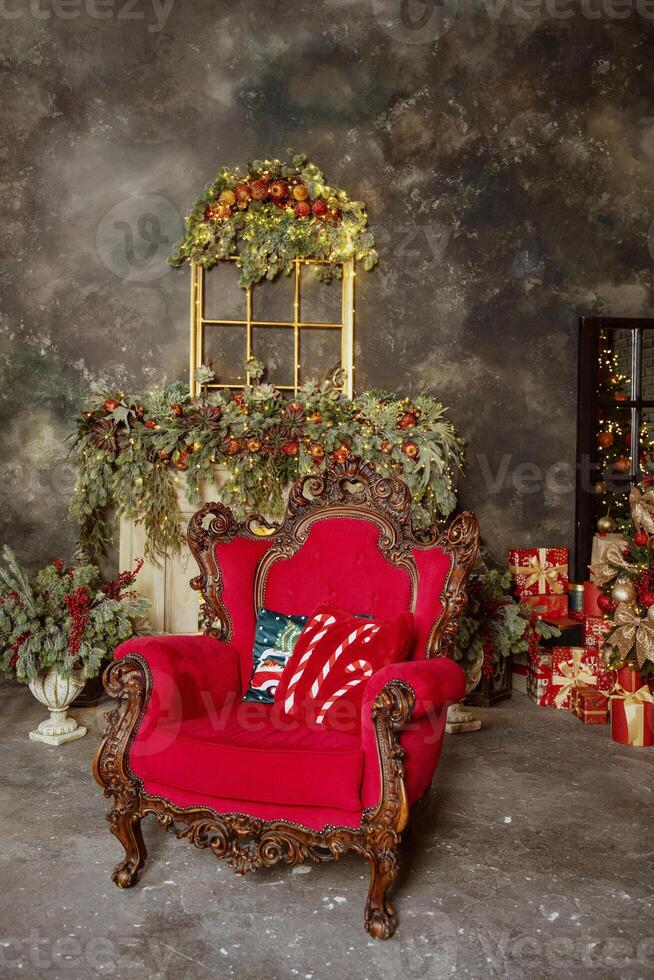 A red chair in front of a fireplace with christmas decorations photo