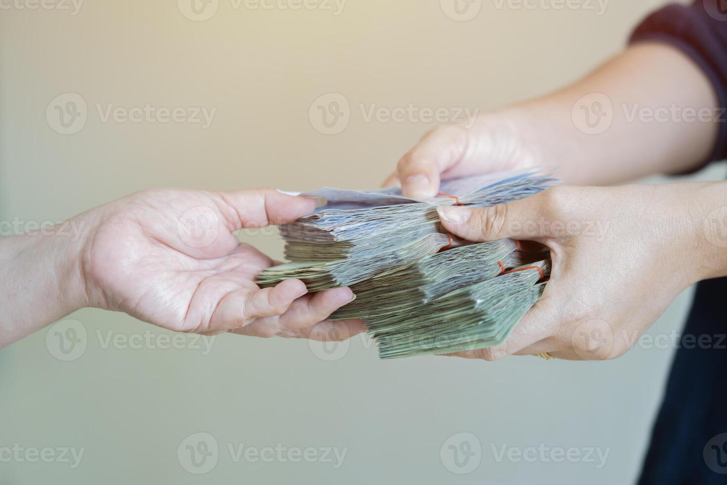 Close up hands giving stack of money over light gray background. photo