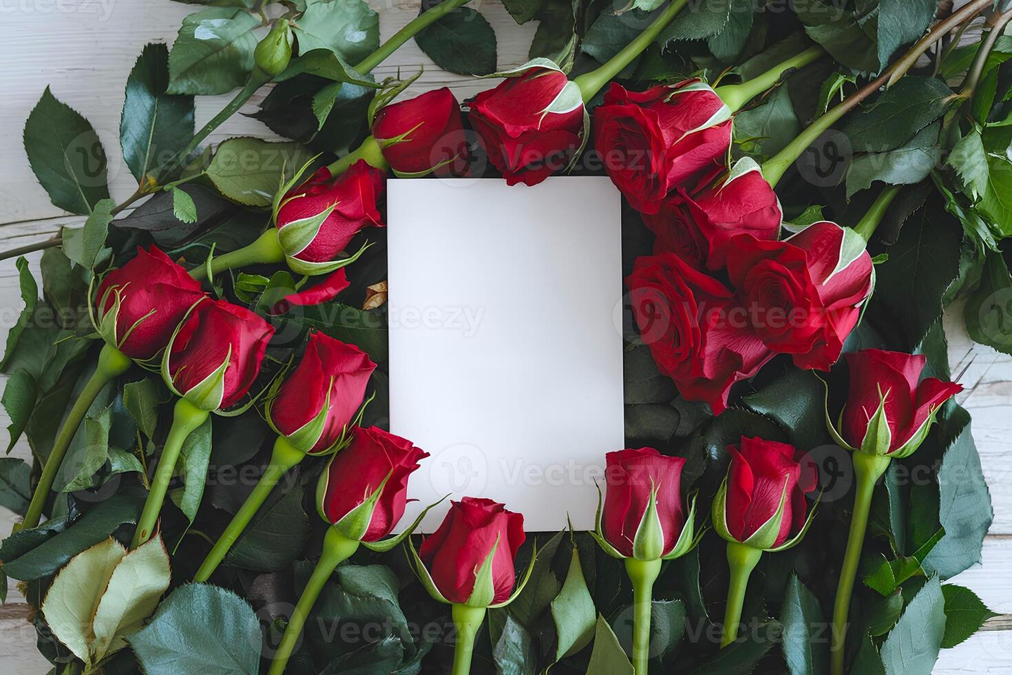 A blank white greeting card is surrounded by bunch of red roses representing concepts like Valentines Day or any such occasions photo