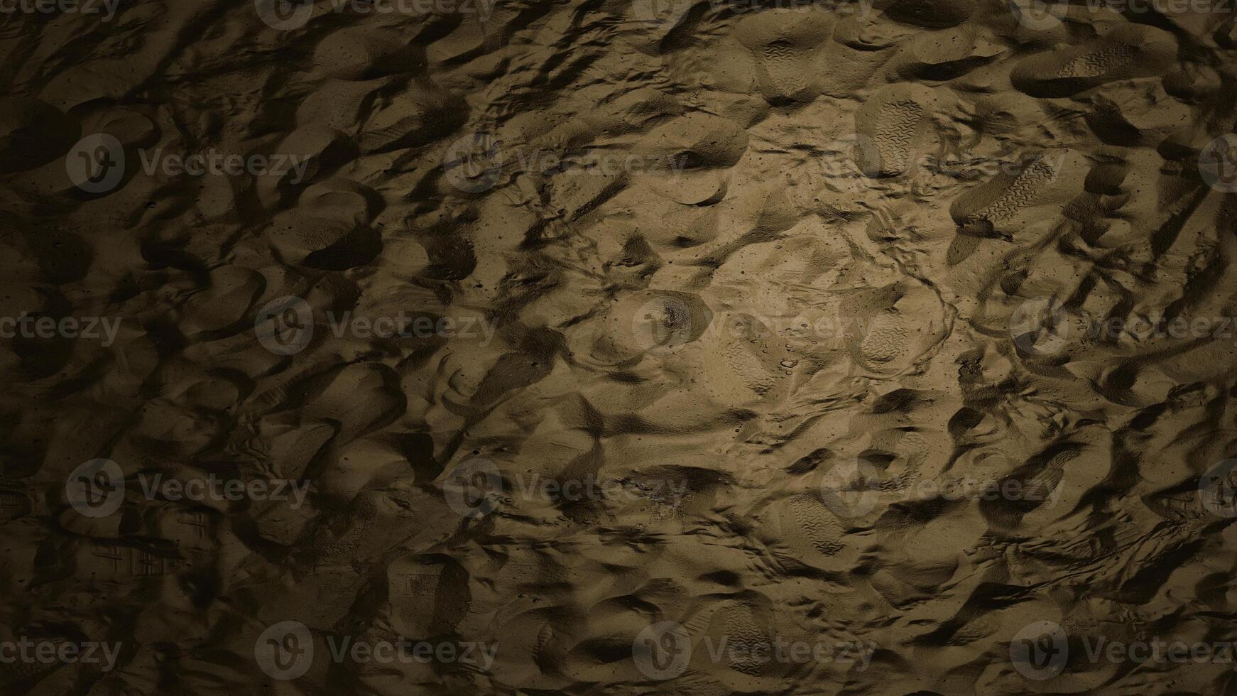 brown sand with lots of footprints photo
