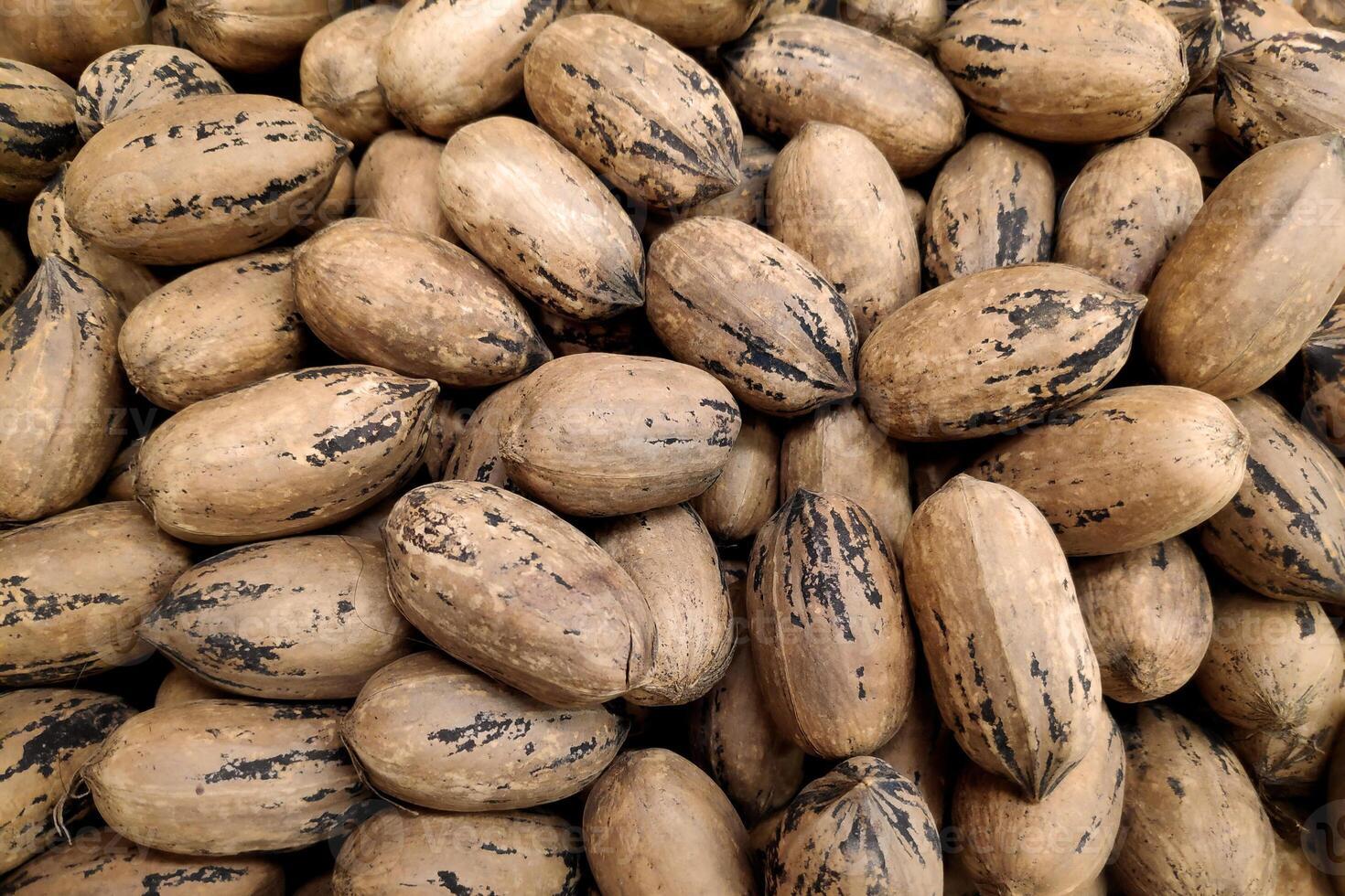Stack of pecan nuts on a market stall photo