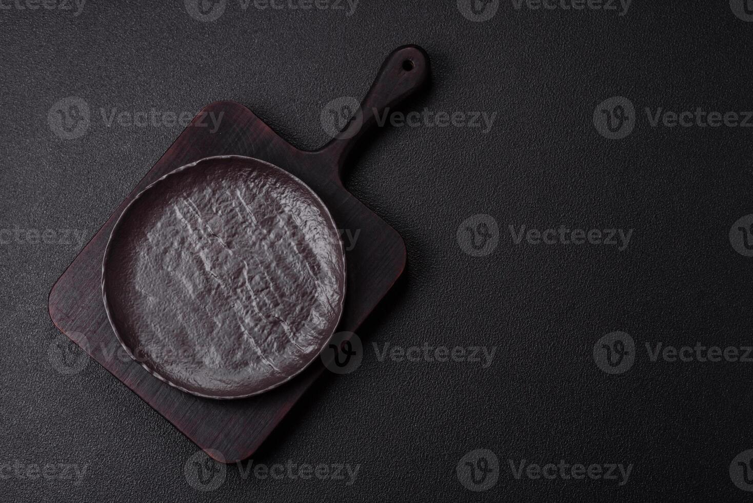 Empty black ceramic plate on a dark concrete background photo