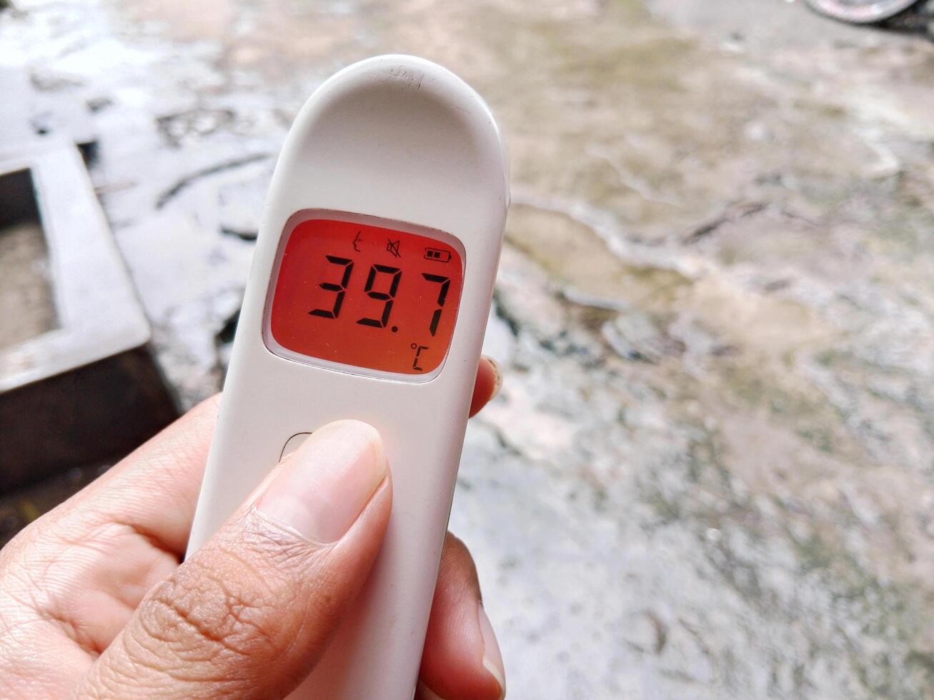 Non-contact digital medical infrared forehead thermometer Reading fever temperature during the rainy season photo