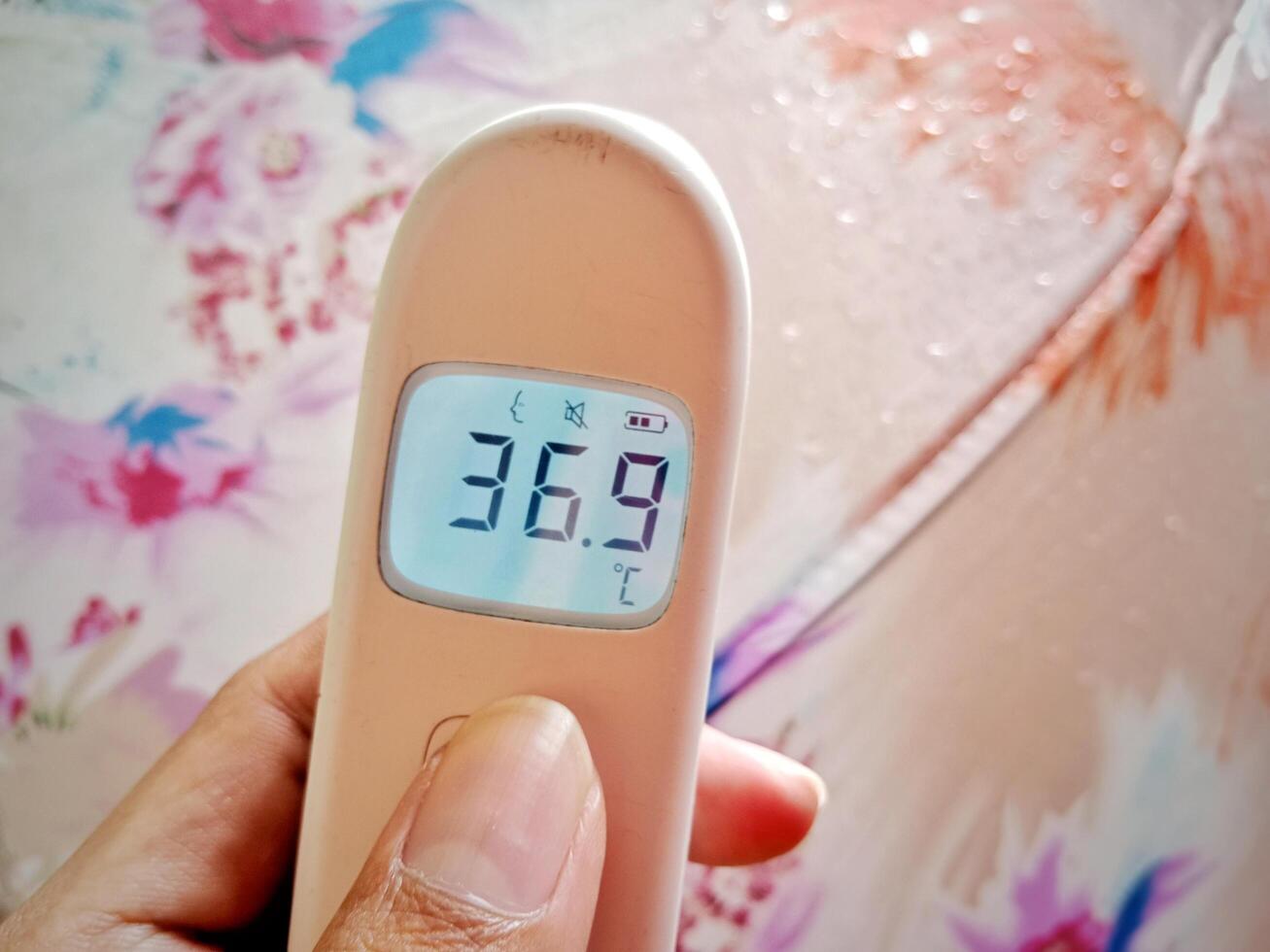 Non contact digital medical infrared forehead thermometer for temperature during rainy season photo