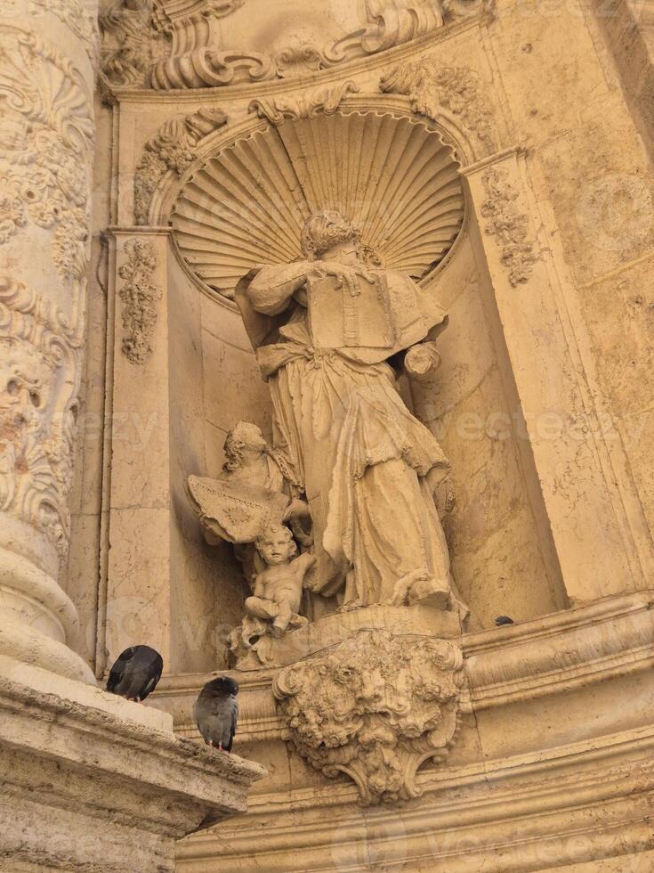 Ancient sculptures of Christian saints on the walls of a Spanish catholic temple photo
