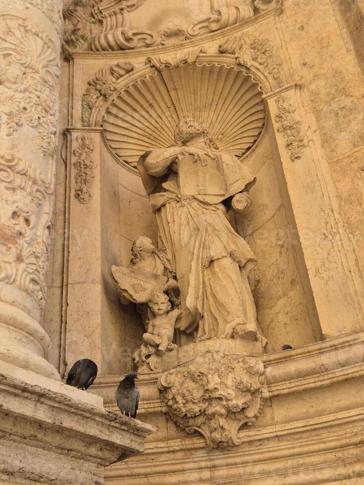 Ancient sculptures of Christian saints on the walls of a Spanish catholic temple photo
