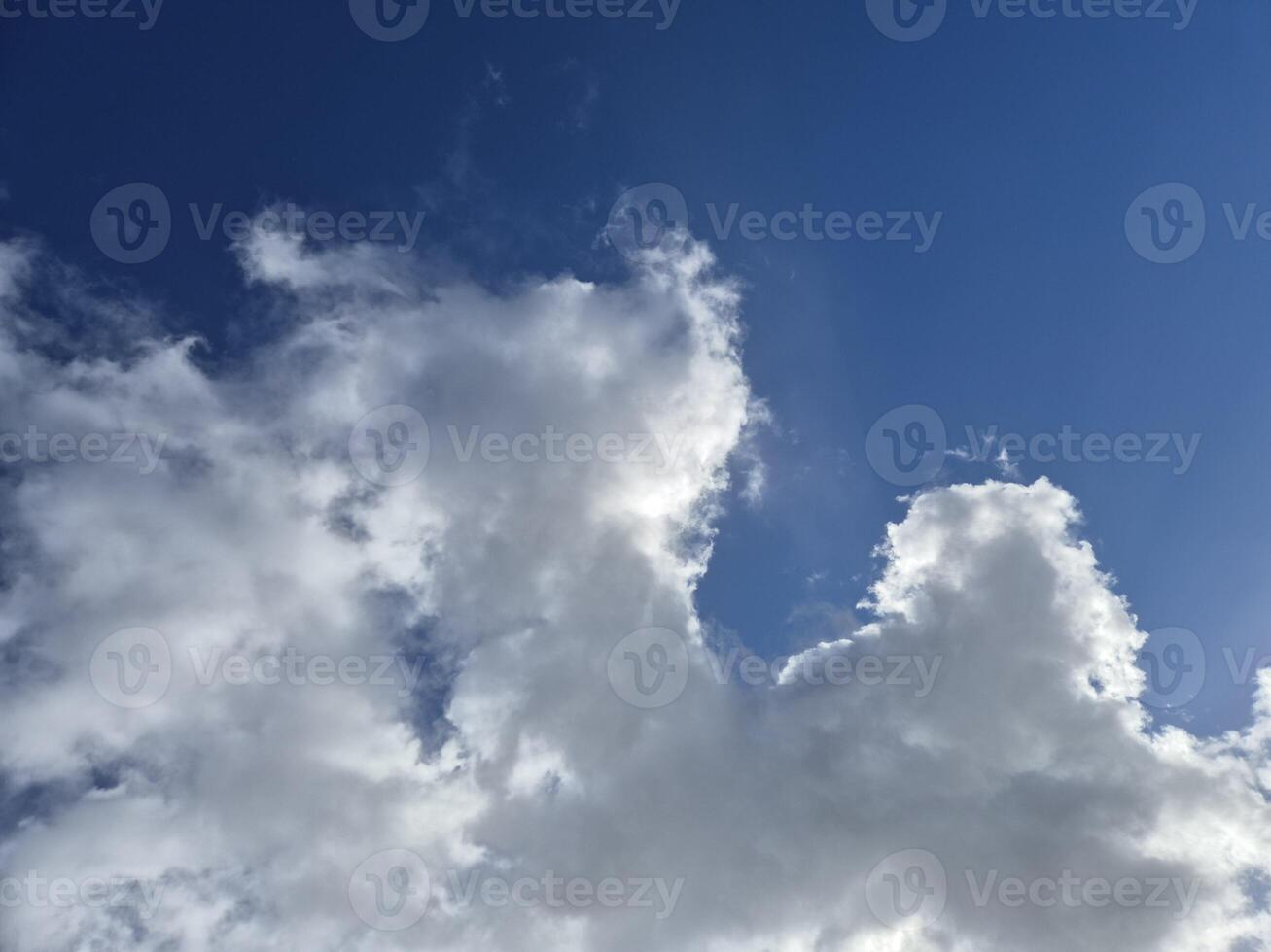 White fluffy cumulus clouds in the summer sky photo