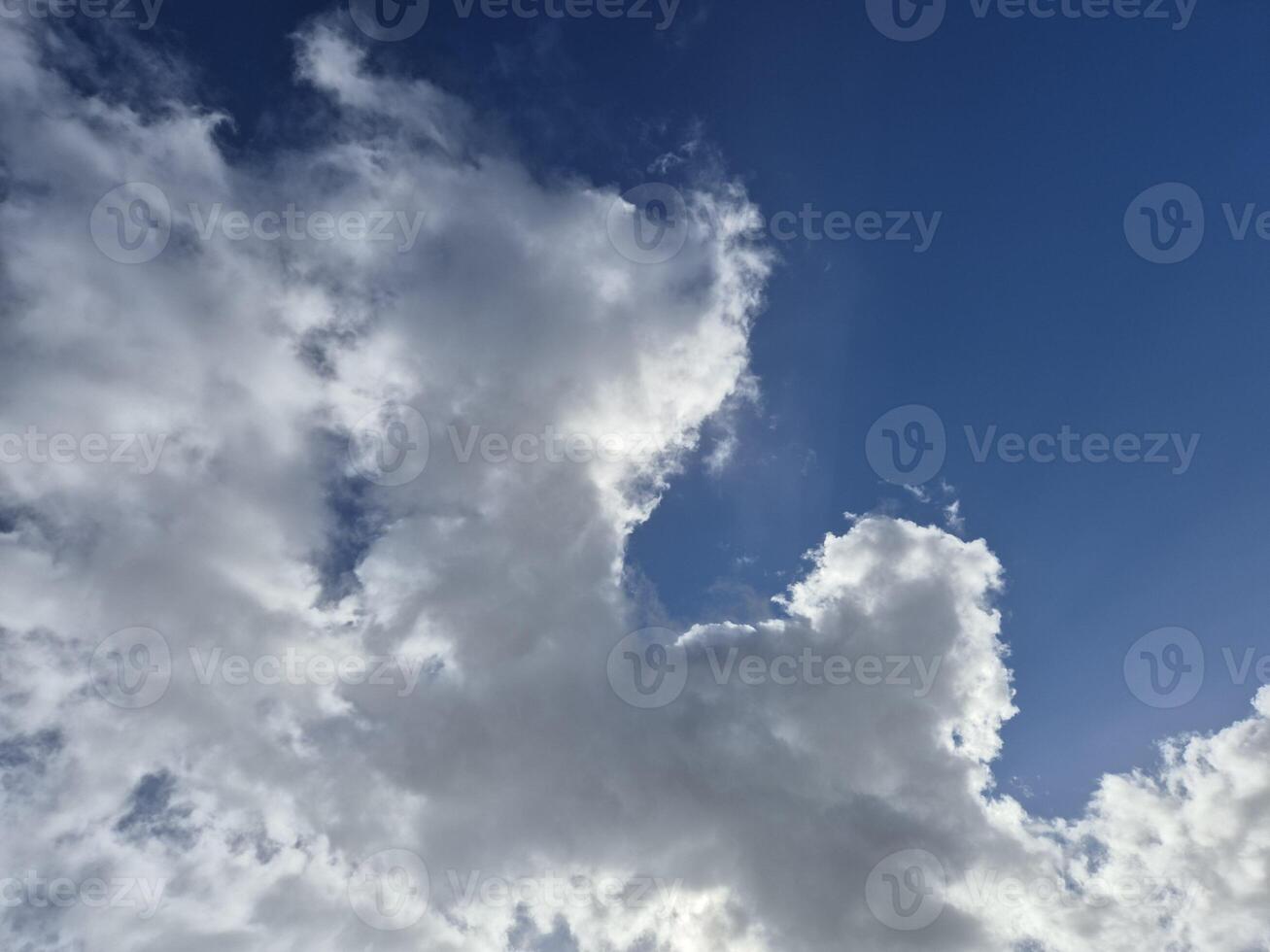 White fluffy cumulus clouds in the summer sky photo