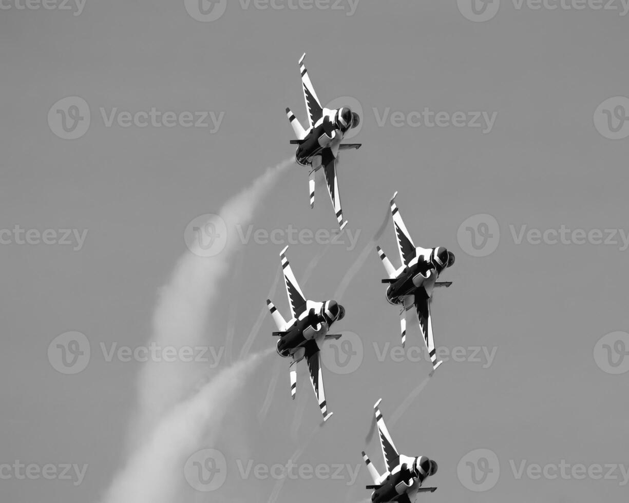 Airshow of military jet fighters. Group of military airplanes performs maneuvers with a smoke trace. Aviation background photo