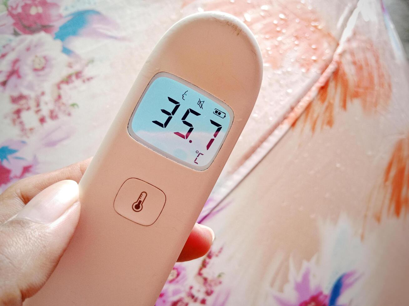 Non contact digital medical infrared forehead thermometer for temperature during rainy season photo