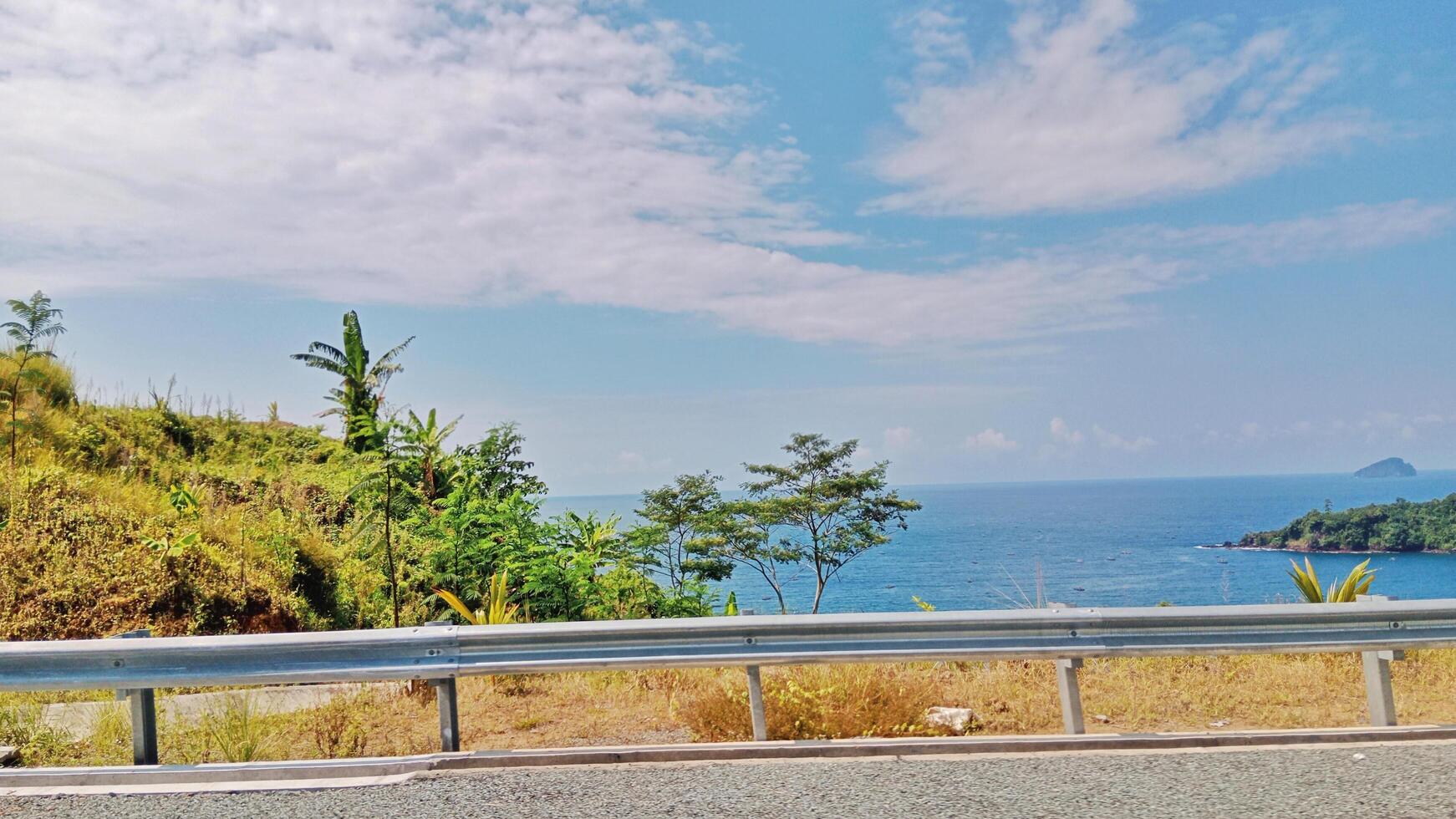 Beautiful Hillside Road View with Bright Blue Sky and Open Skyline photo
