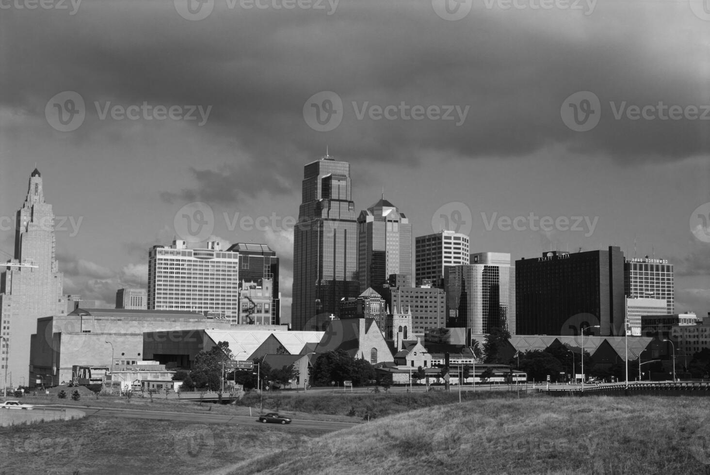 Urban Skyline with Skyscrapers and Greenery Against a Cloudy Sky photo