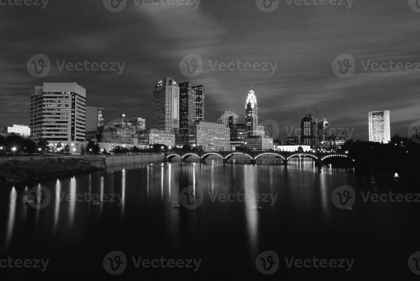 Serene Dusk Reflection of Skyscrapers on a Tranquil Lake Under a Cloudy Sky photo