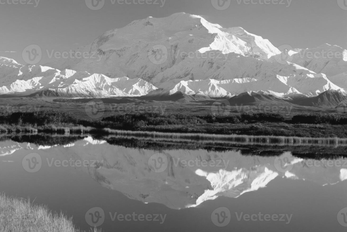 Majestic Highland Landscape Snow-Capped Mountains and Tranquil Waters Under a Blue Sky photo