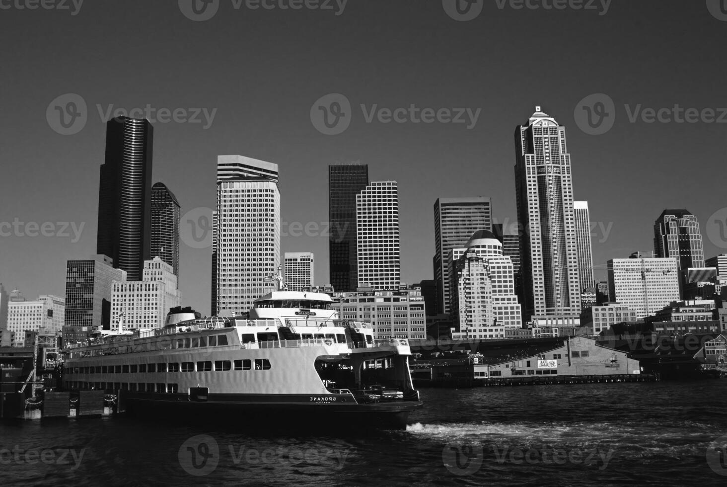 Majestic Skyscraper Reflected in Calm Waters with Boats Nearby photo