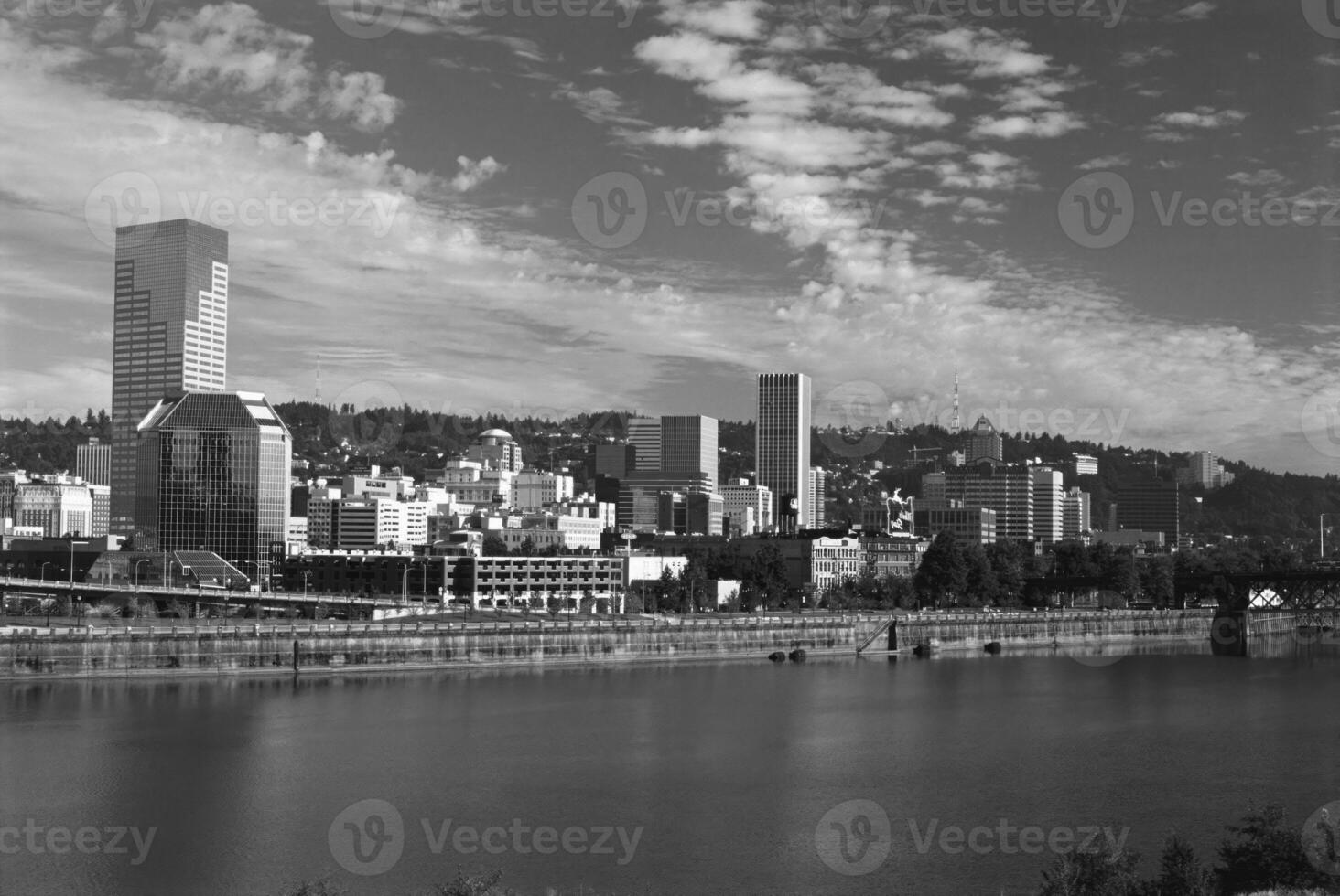 Modern Skyscraper Reflected in Water Under a Blue Sky with Fluffy Clouds photo