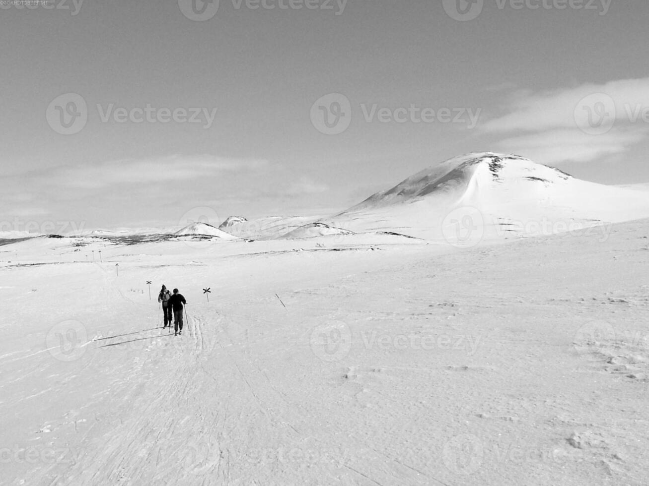 Snow-Covered Mountain Slope with Ski Equipment and Clouds in the Sky photo